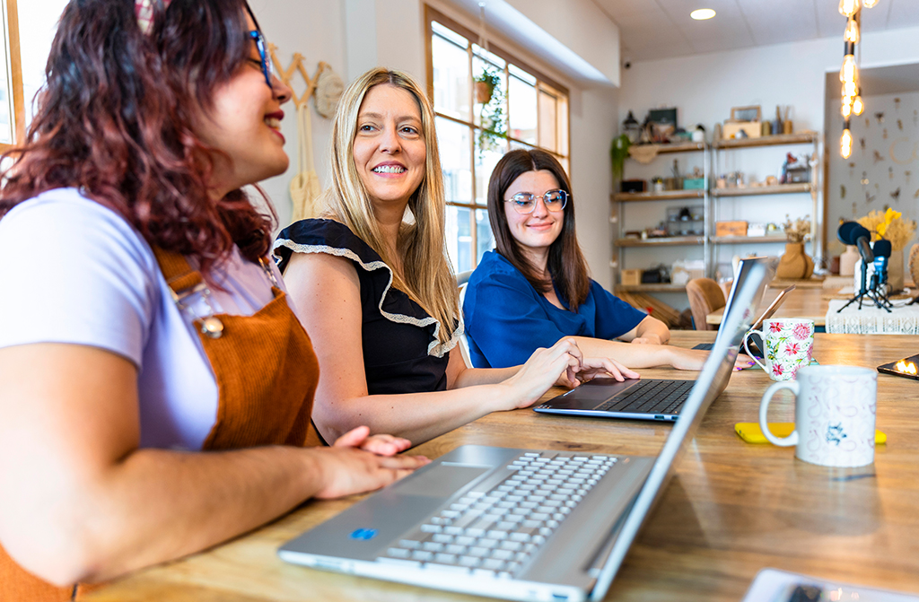 Menschen am Arbeitstisch vor Laptops planen Content