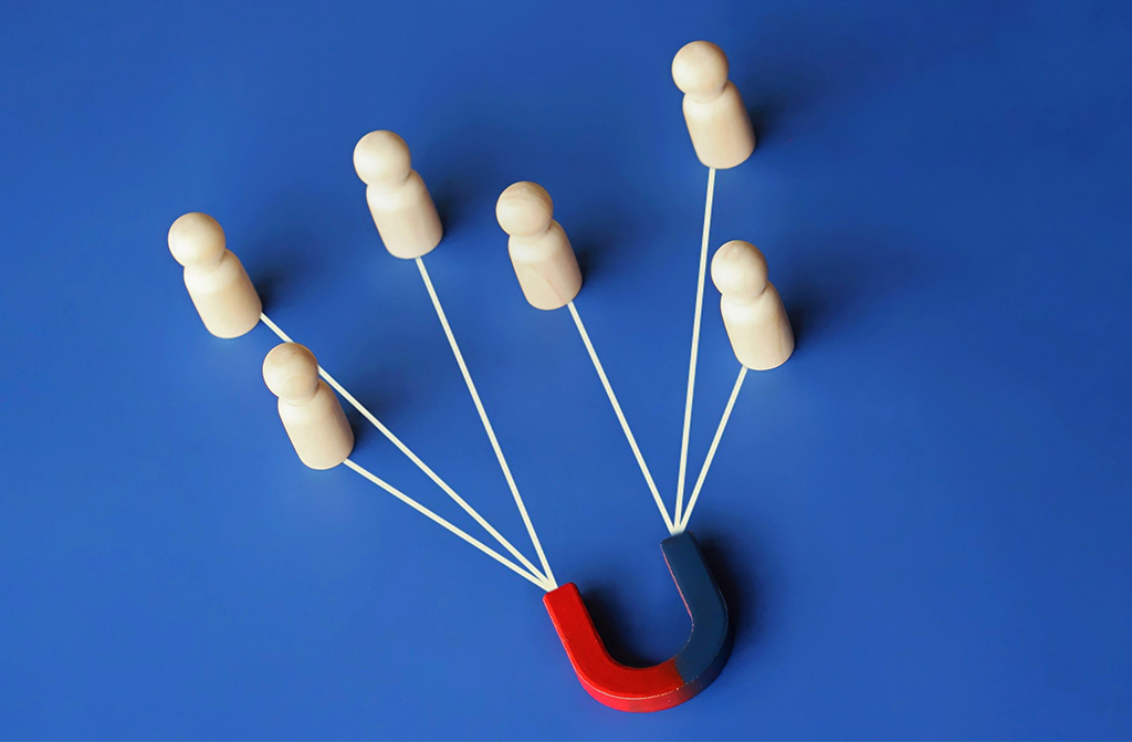 Magnet, der mittels Fäden gebastelte Menschen verbindet